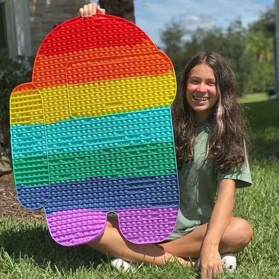 Girl sitting on grass holding Biggest Pop It Fidget Toys kibtoy