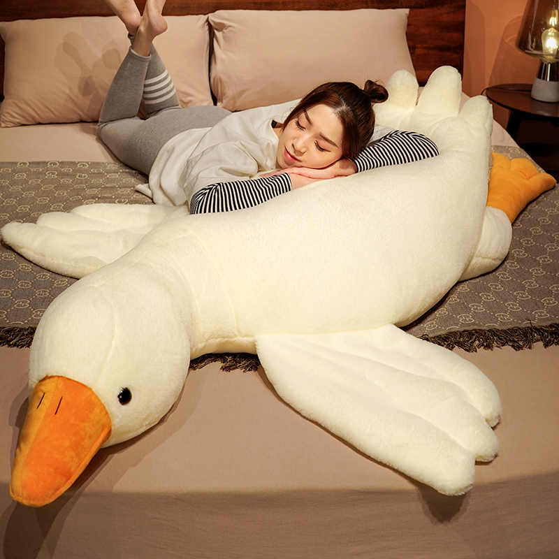 girl lying on a giant swan weighted stuffed animal