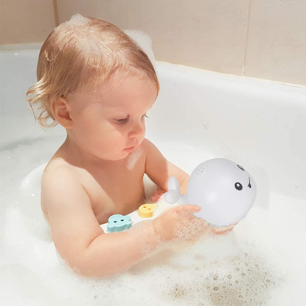 Baby enjoys playing with whale bath toy